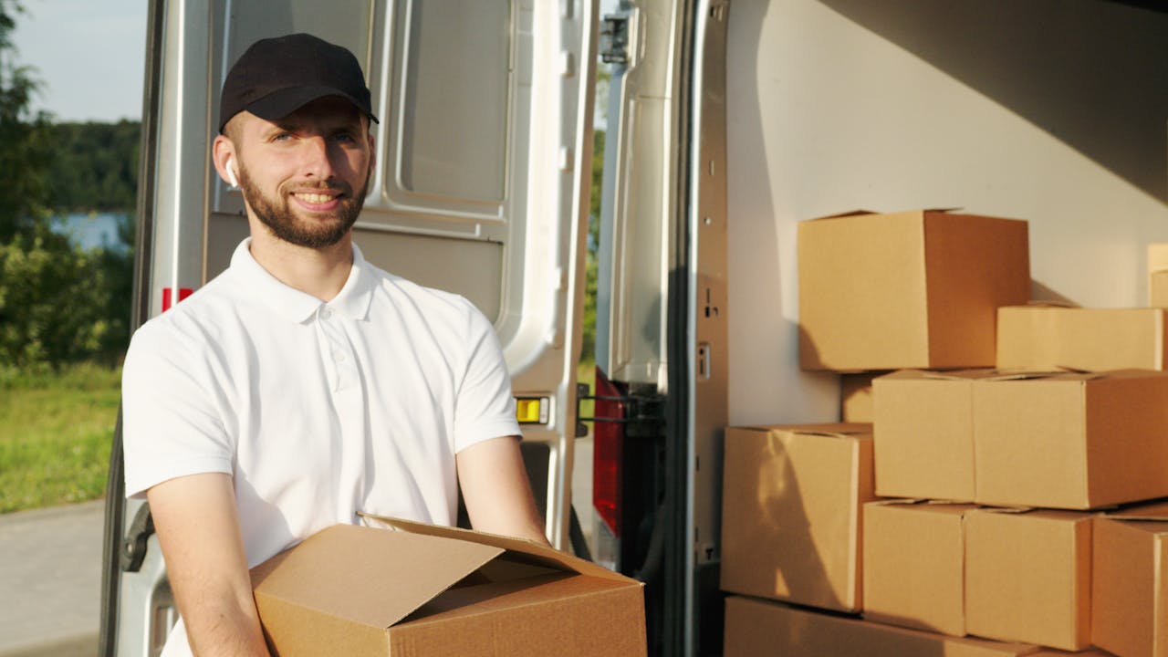 Man Smiling while Holding a Box